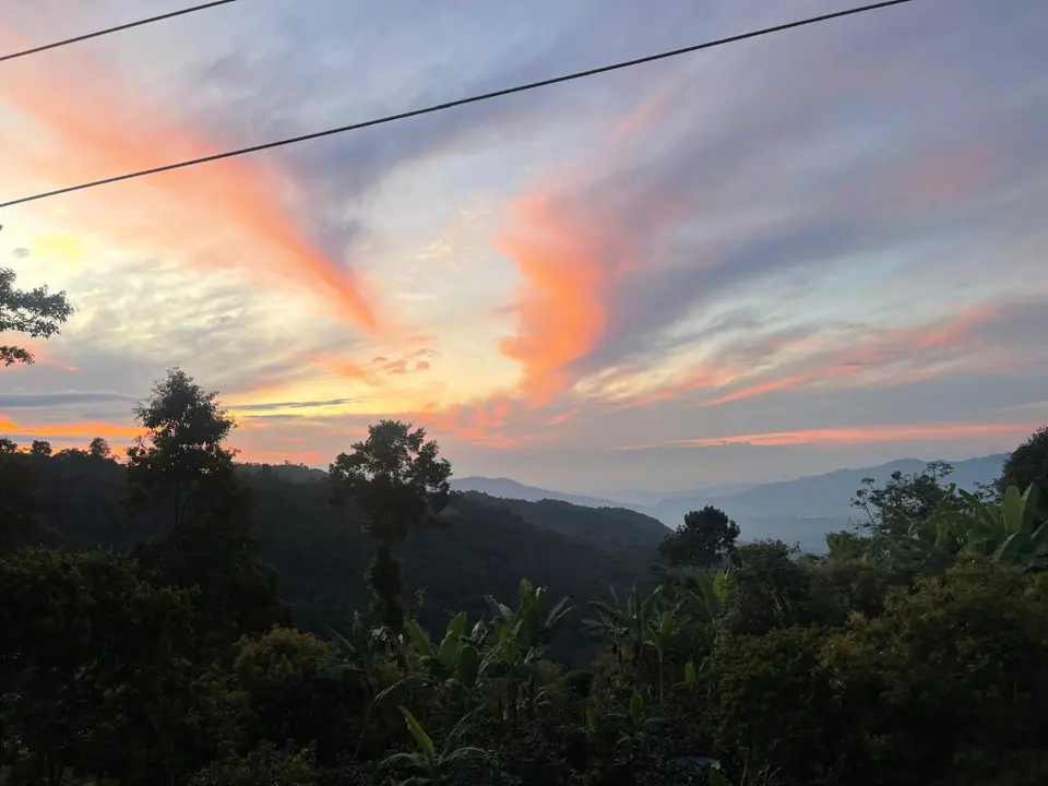Tonos cálidos iluminan el cielo sobre las montañas.
