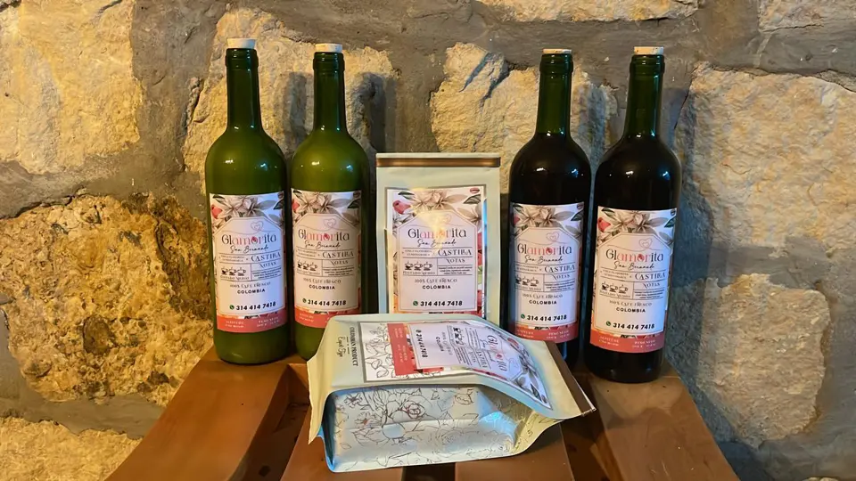 Botellas y productos presentados junto a un muro de piedra.